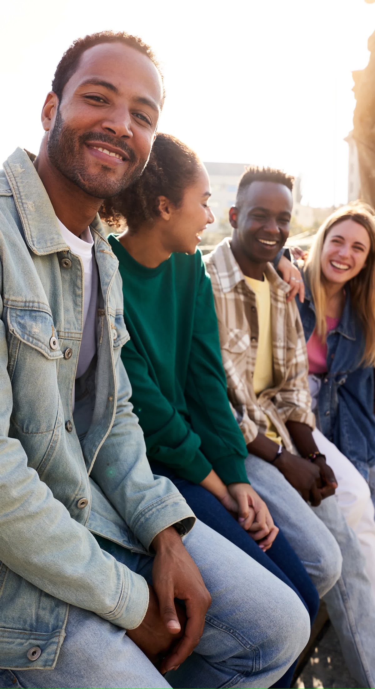 Friends smiling and sitting outdoors